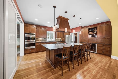 Gather around this spacious kitchen's island, where rich wood cabinetry, modern stainless appliances, and pendant lighting create your perfect home-away-from-home for preparing and sharing memorable meals together.