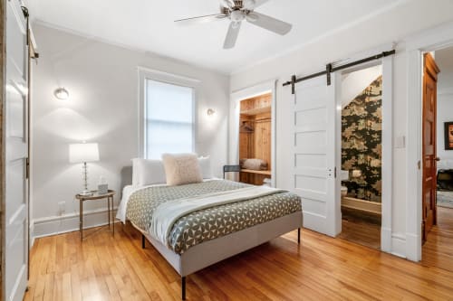 Relax in your stylish bedroom with gleaming hardwood floors, a cozy reading chair, and charming barn door leading to your private spaces.
