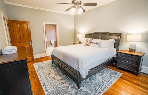 Rest peacefully in your elegant bedroom featuring a plush king bed, hardwood floors, and cozy en-suite bathroom for ultimate comfort.
