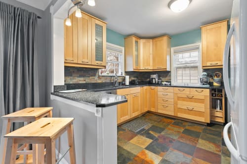 Your fully-equipped kitchen features warm wood cabinets, granite counters, and modern appliances for cooking memorable meals during your stay.