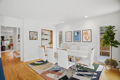 Your bright dining space features a sleek white table with comfortable seating, perfect for morning coffee or evening meals together.