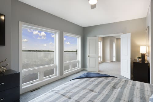 Wake up to serene lake views from your comfortable bedroom, where morning light streams through expansive windows and peaceful waters set the perfect tone for your day.