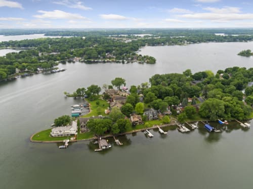 Stunning aerial view of lakefront community with private docks and wooded shoreline stretching across pristine waters.