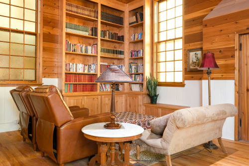 Curl up with your favorite book in this cozy wood-paneled library, featuring leather armchairs and floor-to-ceiling bookshelves bathed in natural light.
