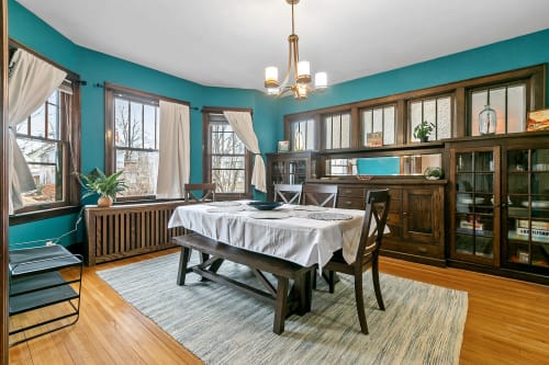 Gather around this stunning dining table where vibrant turquoise walls and warm wood create the perfect backdrop for your memorable meals together.