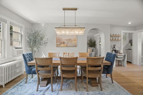 Gather around this elegant dining table, where the chandelier casts a warm glow and every meal becomes a celebration. The open layout lets conversation flow naturally into the cozy spaces beyond.