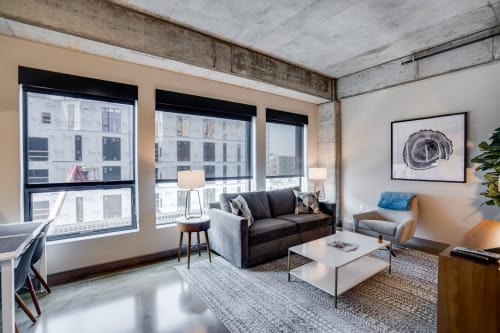 Relax in your stylish industrial loft with soaring concrete ceilings, oversized windows, and modern furnishings creating the perfect urban retreat.