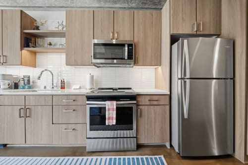 Modern, fully equipped kitchen with stainless steel appliances, ample counter space, and warm wood cabinetry ready for your culinary adventures.