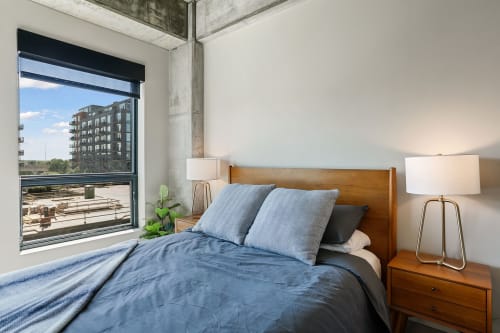Drift off to sleep in this serene bedroom with modern touches and expansive city views from your private window.