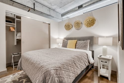 Sink into luxurious comfort in your industrial-chic bedroom, where exposed concrete meets soft textures and thoughtful design touches create perfect urban serenity.