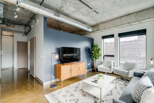 Relax in your modern living room featuring stylish furniture, exposed concrete ceilings, and sleek industrial design details that create an urban loft atmosphere.