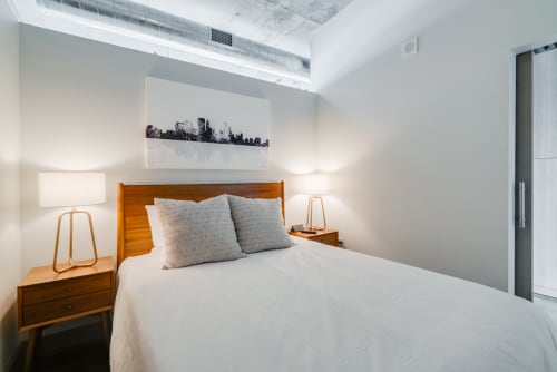 Sink into your cozy bedroom sanctuary with crisp linens, warm wood accents, and industrial-chic exposed ceilings.