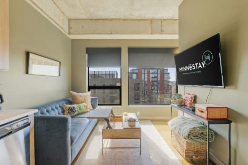 Unwind in your modern living space with exposed ceilings, comfortable seating, and city views through large windows.