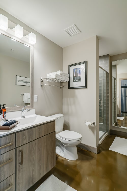 Step into your sleek bathroom featuring modern vanity, walk-in shower, and thoughtful amenities for your comfort.