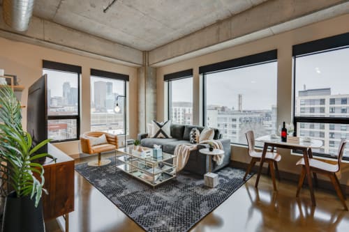 Relax in your sophisticated living space with floor-to-ceiling windows showcasing stunning city views, modern furnishings, and an open layout perfect for unwinding.