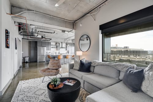 Relax in your sophisticated loft with exposed concrete ceilings, modern furnishings, and sweeping city views through floor-to-ceiling windows.