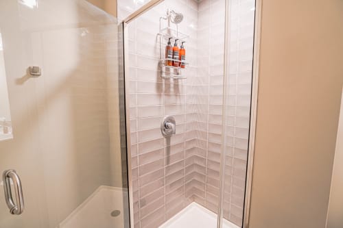 Step into your pristine glass-enclosed shower with luxurious rainfall head and premium toiletries waiting for your refreshing start.