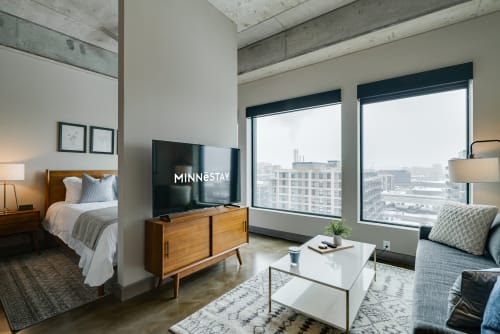 Unwind in your modern studio with exposed concrete ceilings, city views, and thoughtful touches creating an urban retreat.