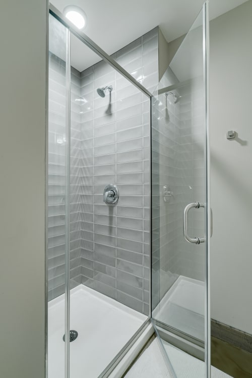 Step into your sleek glass-enclosed shower featuring elegant subway tiles and modern fixtures for a refreshing start to your day.