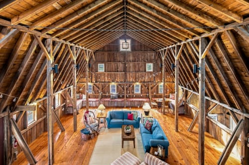 Step into this stunning converted barn where soaring timber beams frame your spacious living area, and warm wooden floors invite you to unwind on plush sofas beneath cathedral ceilings that make every moment feel extraordinary.