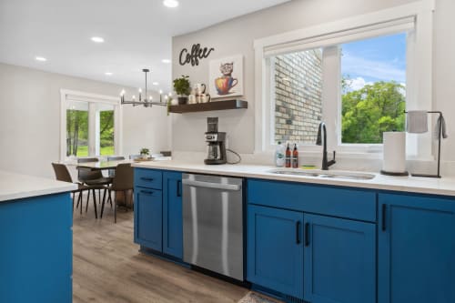 Your bright, modern kitchen features bold blue cabinets and gleaming countertops where you'll love preparing meals with garden views.