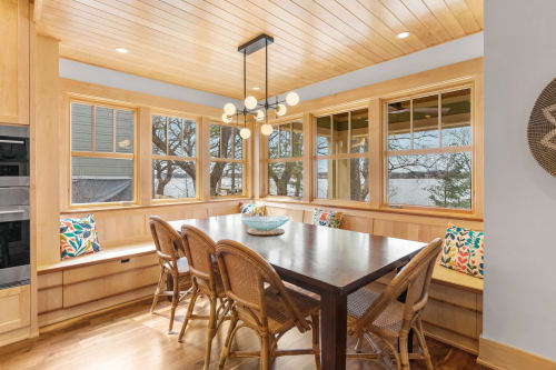 Gather around your cozy breakfast nook with built-in benches and colorful cushions, where warm wood tones and natural light create the perfect spot for morning coffee.