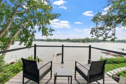 Stunning lakefront deck where you'll unwind with panoramic water views, complete with comfortable seating for peaceful mornings and breathtaking sunsets.