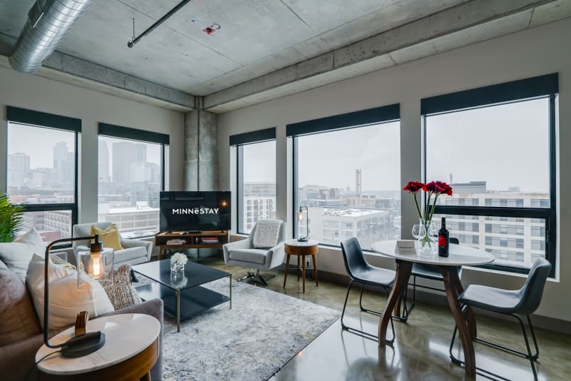 Relax in your stylish living space with floor-to-ceiling windows showcasing stunning city views, modern furnishings, and an open layout perfect for unwinding.
