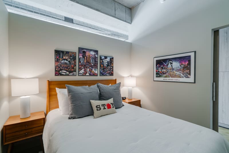 Sink into crisp white linens and admire vibrant local art from your modern bedroom retreat with stylish mid-century furnishings.