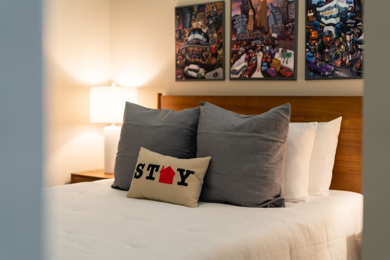 Sink into this cozy bed with playful pillows and vibrant artwork creating your perfect creative retreat.