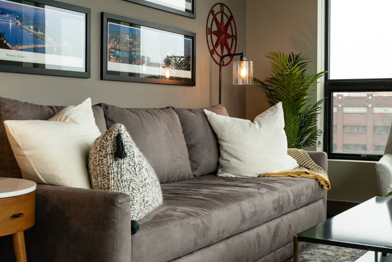 Sink into your cozy living room with plush gray sofa, soft throws, and warm lighting-perfect for relaxing after exploring the city.