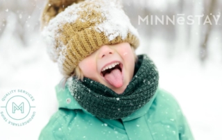 Child in a winter coat catching snow flakes on their tongue at the Winter Carnival in St. Paul Minnesota